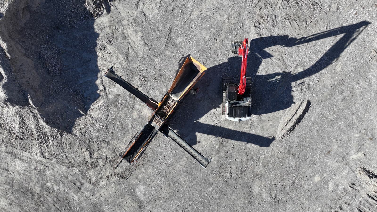 Overhead drone view of screening equipment, conveyors and a red excavator at the J6 Rock pit