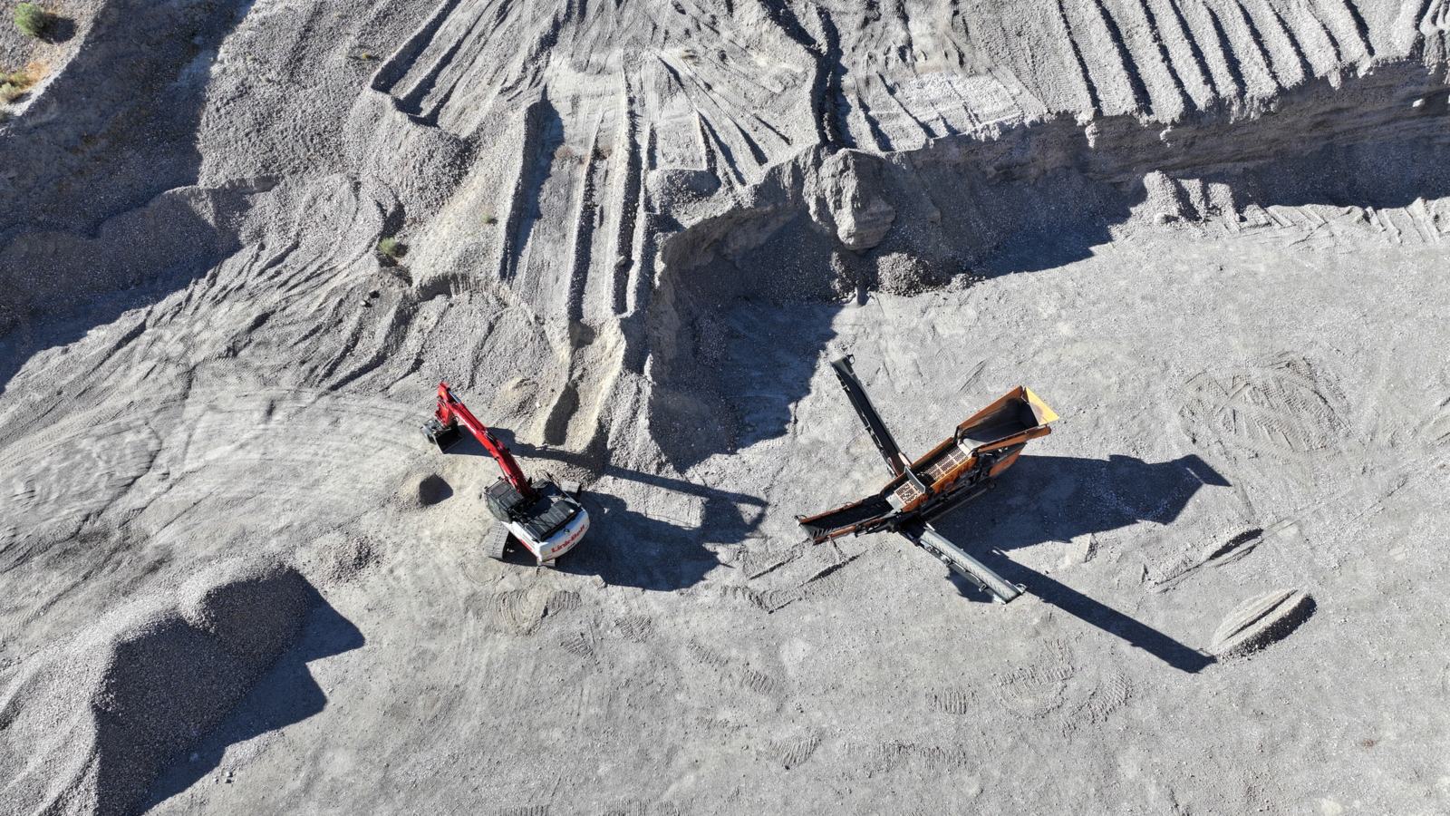 Red excavator and screening equipment below a gravel face at the J6 Rock pit